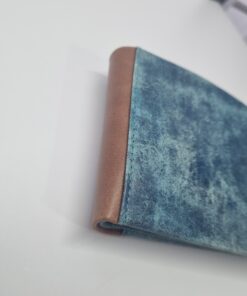 Δερμάτινο αντρίκιο πορτοφόλι σε μπλε χρώμα και καφέ λεπτομέρεια στο πλευρό.